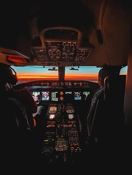 pexels photo 14773595 14773595 Glowing cockpit interior of an airplane, showcasing pilots navigating through sunset skies.